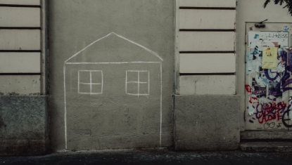 House drawn with chalk on the side of a building.
